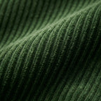 Close-up macro shot of green corduroy fabric showing the fine ribbed weave and soft pile texture