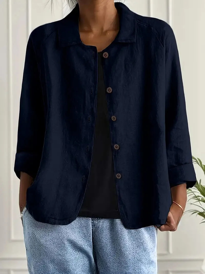 Full front view of a collared shirt jacket worn open over a black top and denim trousers