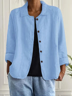 Light blue textured shirt jacket worn open over a black top, showing turned-back cuffs and relaxed fit
