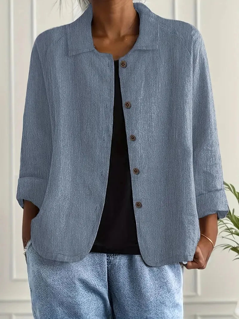 Dusty blue-grey textured cotton-linen shacket worn open over a black top, front view close up