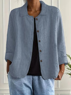 Dusty blue-grey textured cotton-linen shacket worn open over a black top, front view close up