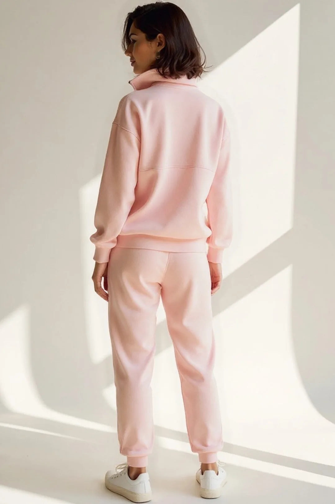 Back view of the pink tracksuit highlighting the drop-shoulder seam and straight-cut joggers