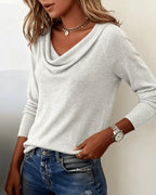 Navy blue cowl neck jumper styled with denim, hand on hip showing the relaxed silhouette