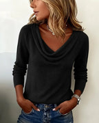 Black cowl neck jumper worn with hands in denim pockets, showing the relaxed drape across the shoulders