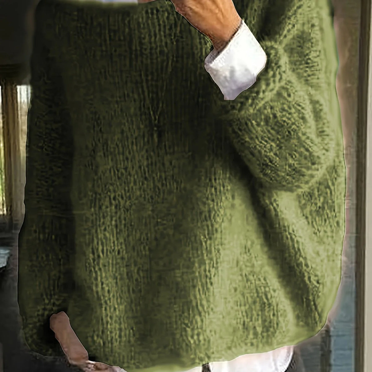 Olive green textured knit jumper worn oversized with a white shirt cuff peeking from the sleeve