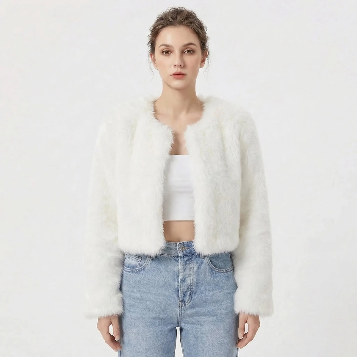 Front view of cropped faux fur jacket in white, open front style worn over a white crop top and jeans