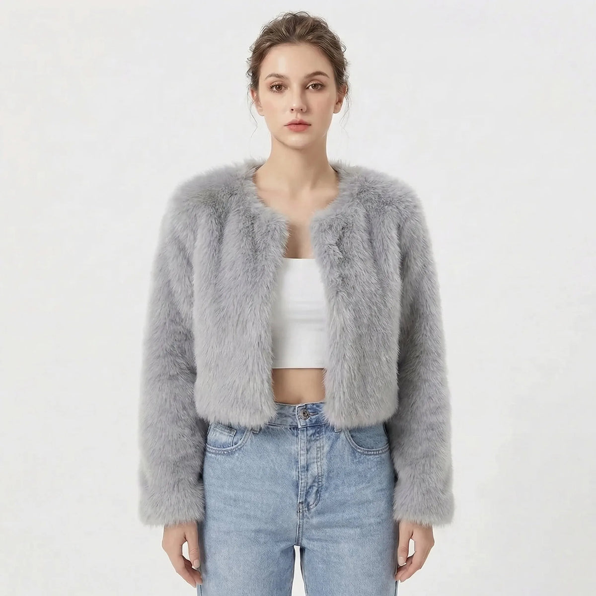 Cropped faux fur jacket in pale silver grey, collarless design with long sleeves, worn open at the front