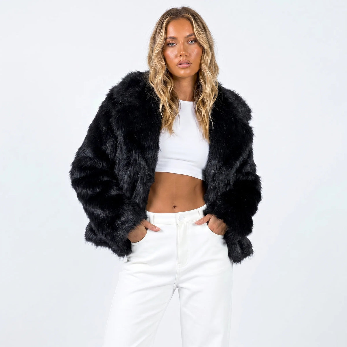 Cropped faux fur jacket in black with voluminous sleeves, worn open over a white top