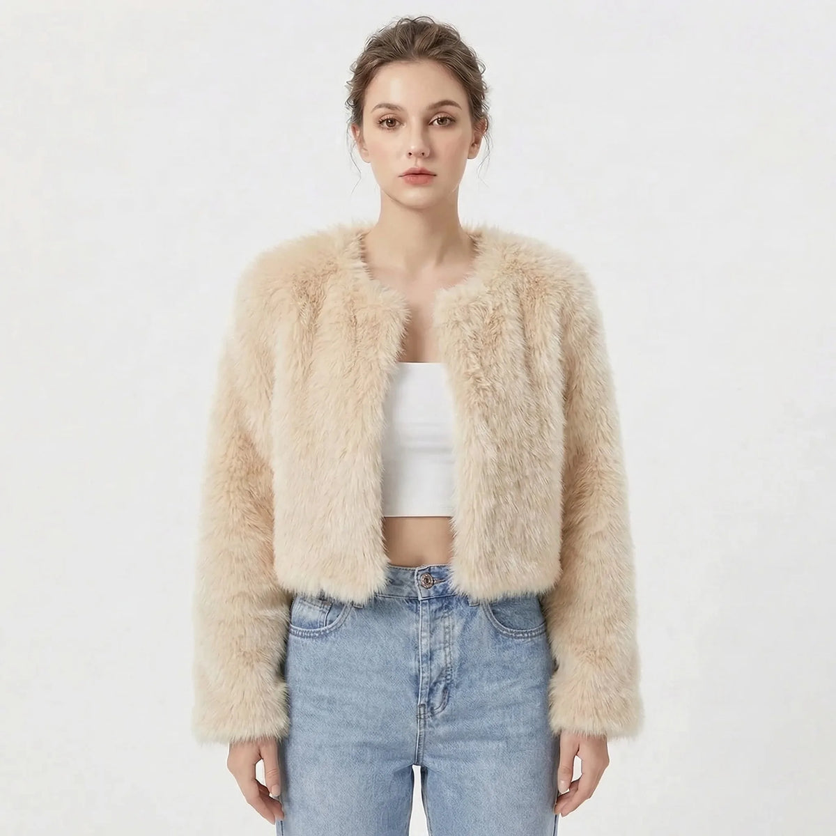 Cropped faux fur jacket in soft apricot tone, collarless open front, worn with high waisted jeans