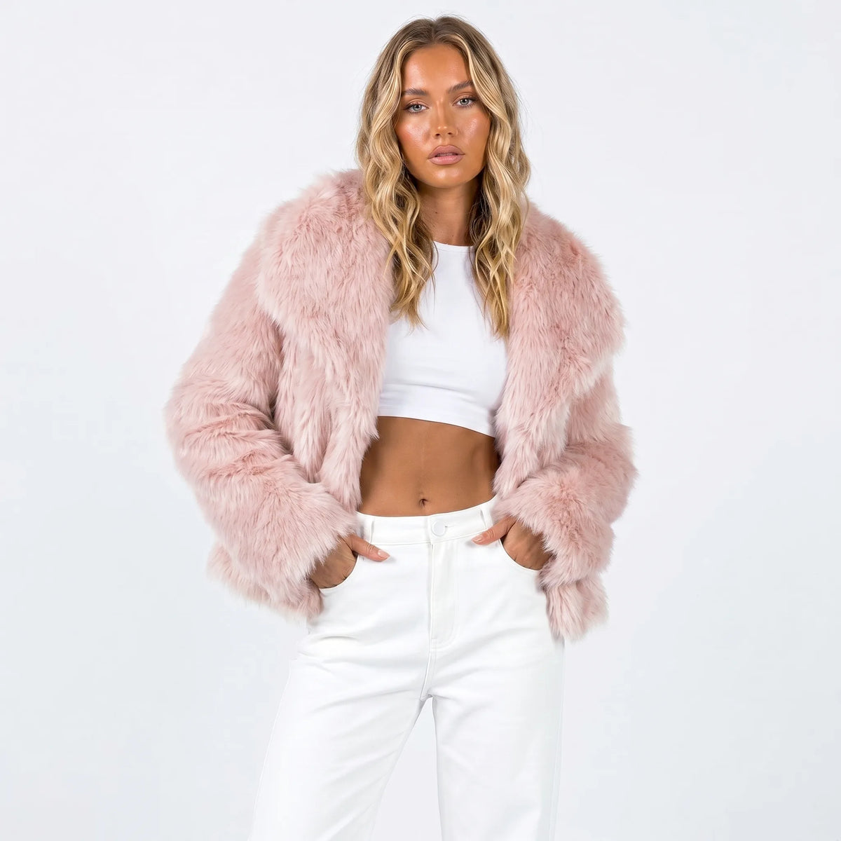 Cropped faux fur jacket in soft pink with fluffy texture, worn over a white crop top and jeans