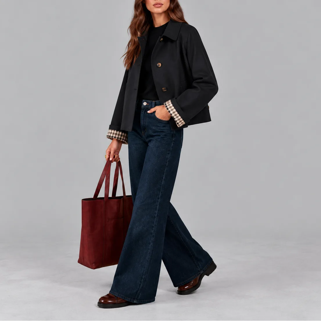 Woman walking in the black cropped jacket with checked lining visible at the sleeve, paired with wide-leg jeans