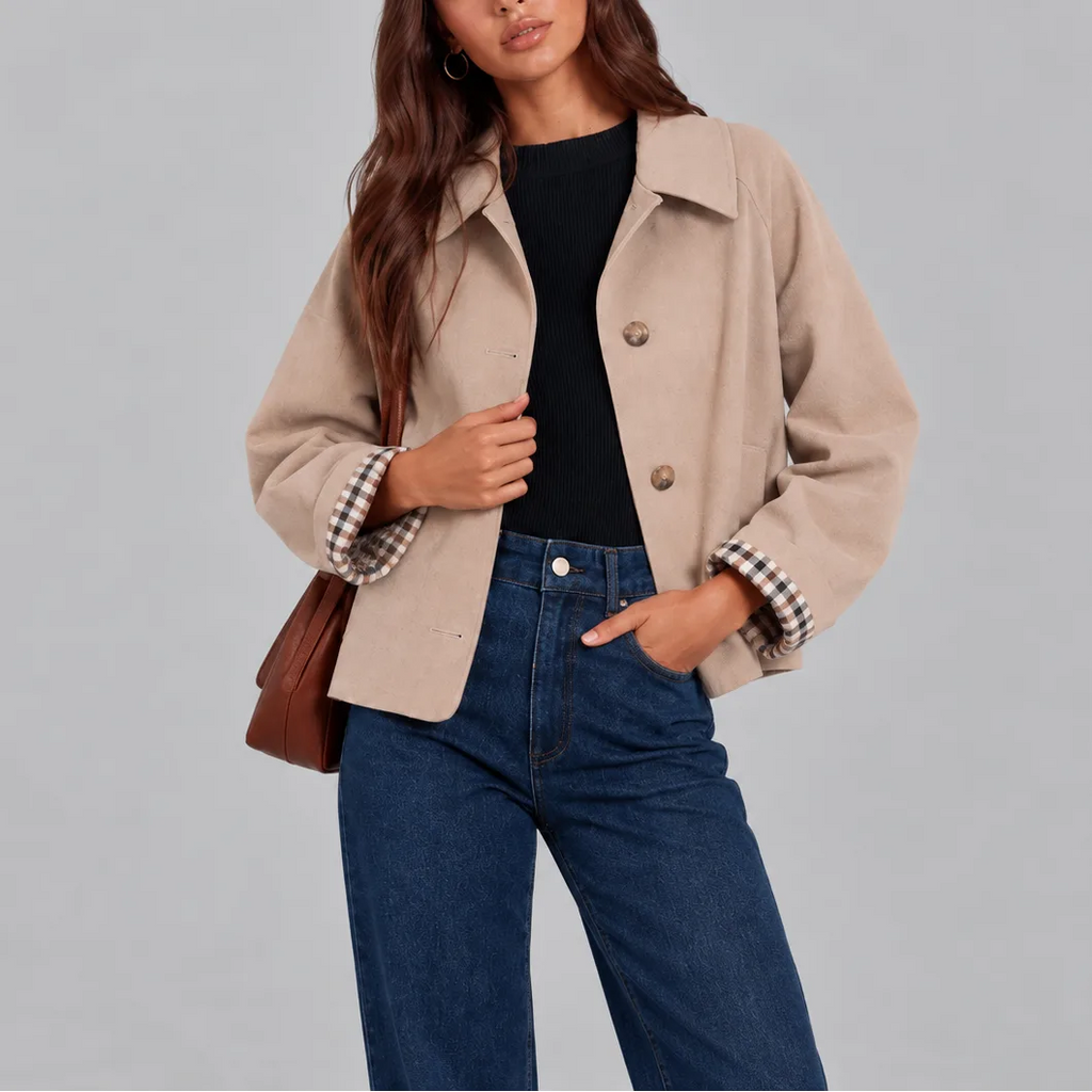 Close-up of the beige cropped jacket showing its soft wool-look fabric, collar and checked cuff lining