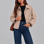 Close-up of the beige cropped jacket showing its soft wool-look fabric, collar and checked cuff lining