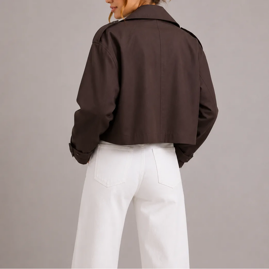 Back view of the dark brown cropped trench jacket showing the boxy silhouette and rolled cuff detail