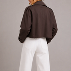 Back view of the dark brown cropped trench jacket showing the boxy silhouette and rolled cuff detail