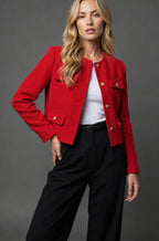 Front view of the pale blue tweed cropped jacket showing the collarless neckline and four flap pockets