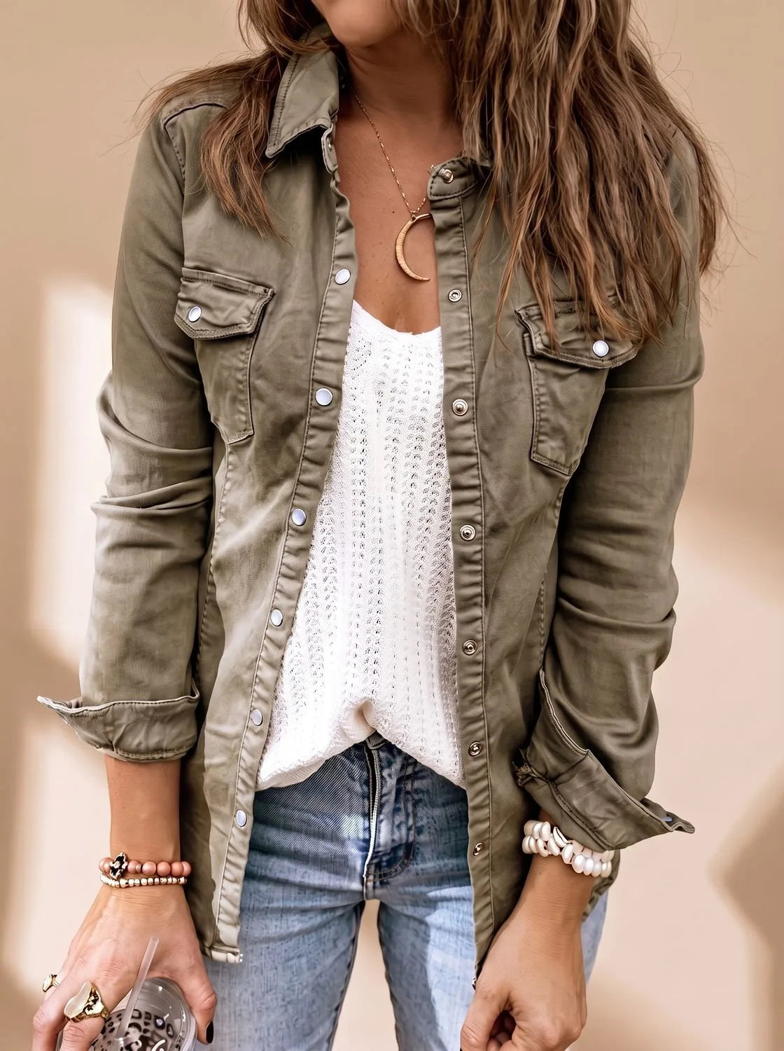 Front view showing the olive green denim jacket fully buttoned with a classic collar and pearl bracelet detail at the cuff