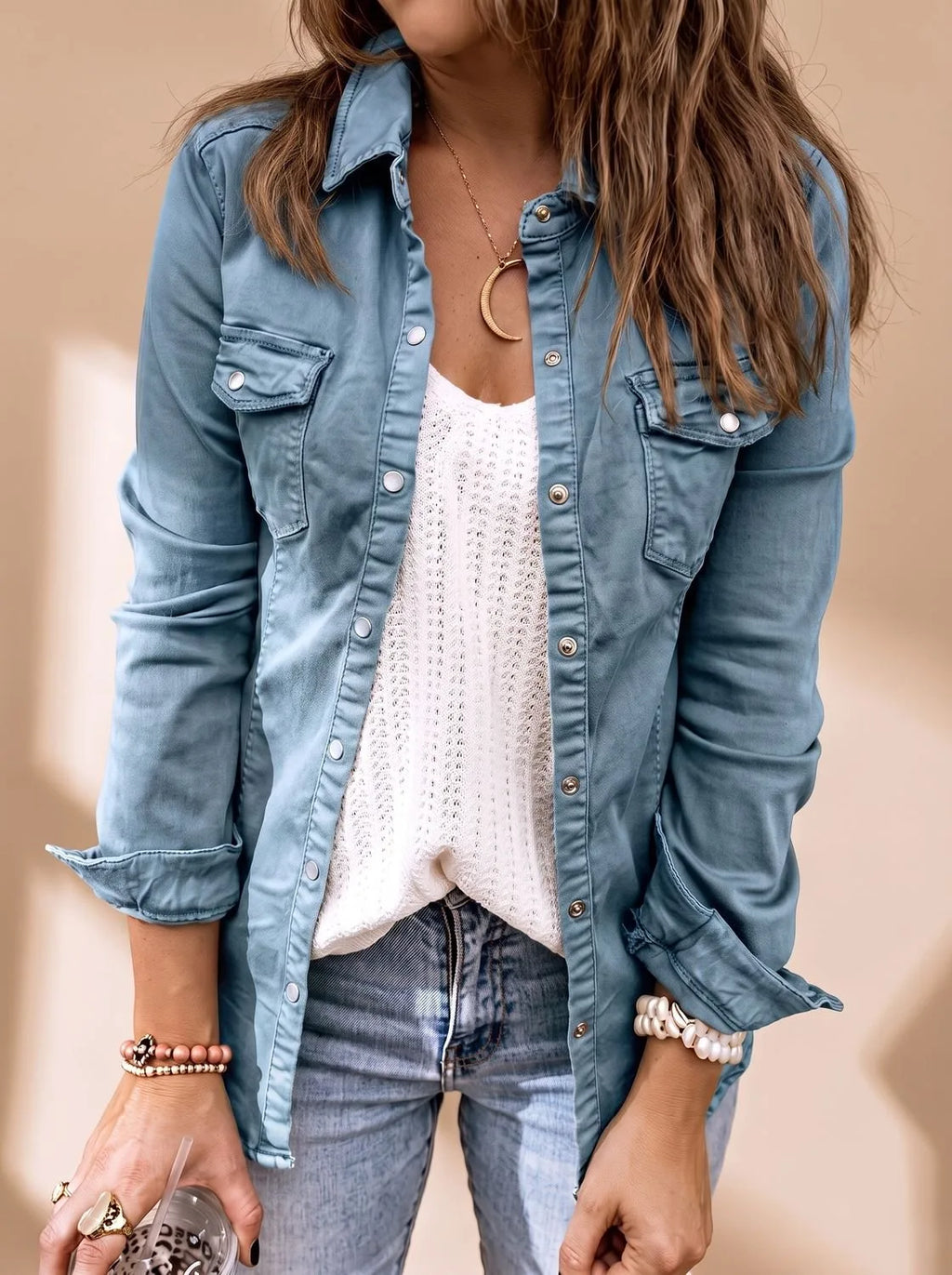 Close-up of the same style jacket in a dusty blue denim wash with snap buttons and twin chest pockets