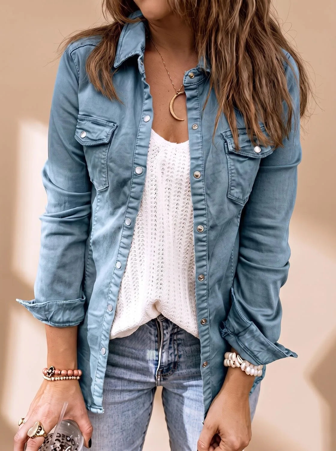 Close-up of the same style jacket in a dusty blue denim wash with snap buttons and twin chest pockets