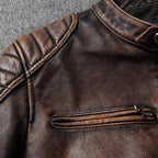 Close-up of quilted shoulder panel and chest zip pocket on brown distressed leather jacket