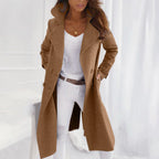 Camel brown double-breasted longline coat with belt loops, shown open with hands in the pockets