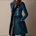 Teal blue double-breasted coat showing structured shoulders and shearling-style panel at the hip