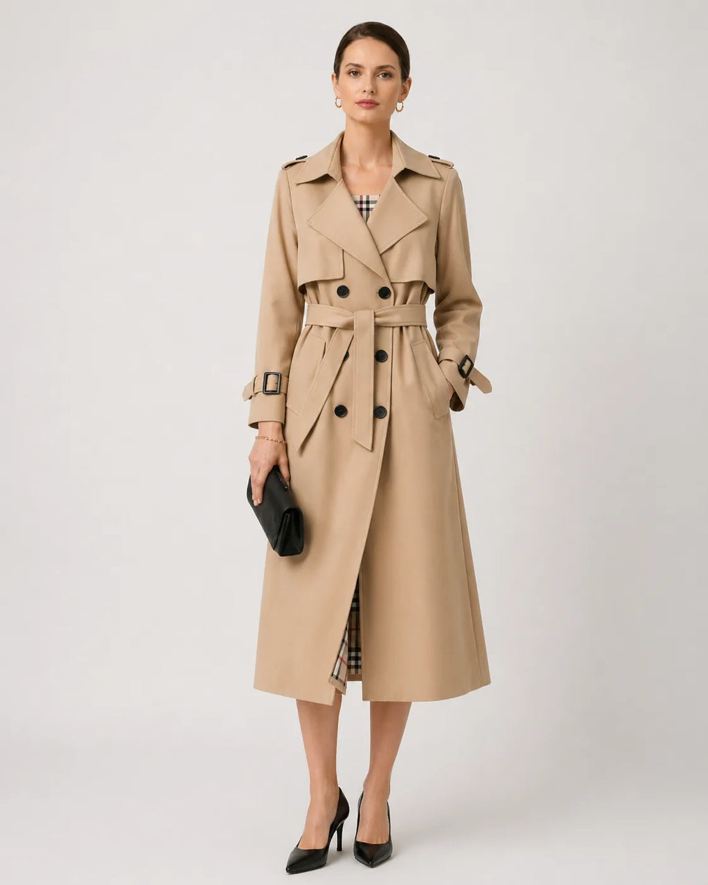 Woman wearing a beige belted trench coat over a checked dress with black heeled shoes, styled for the city