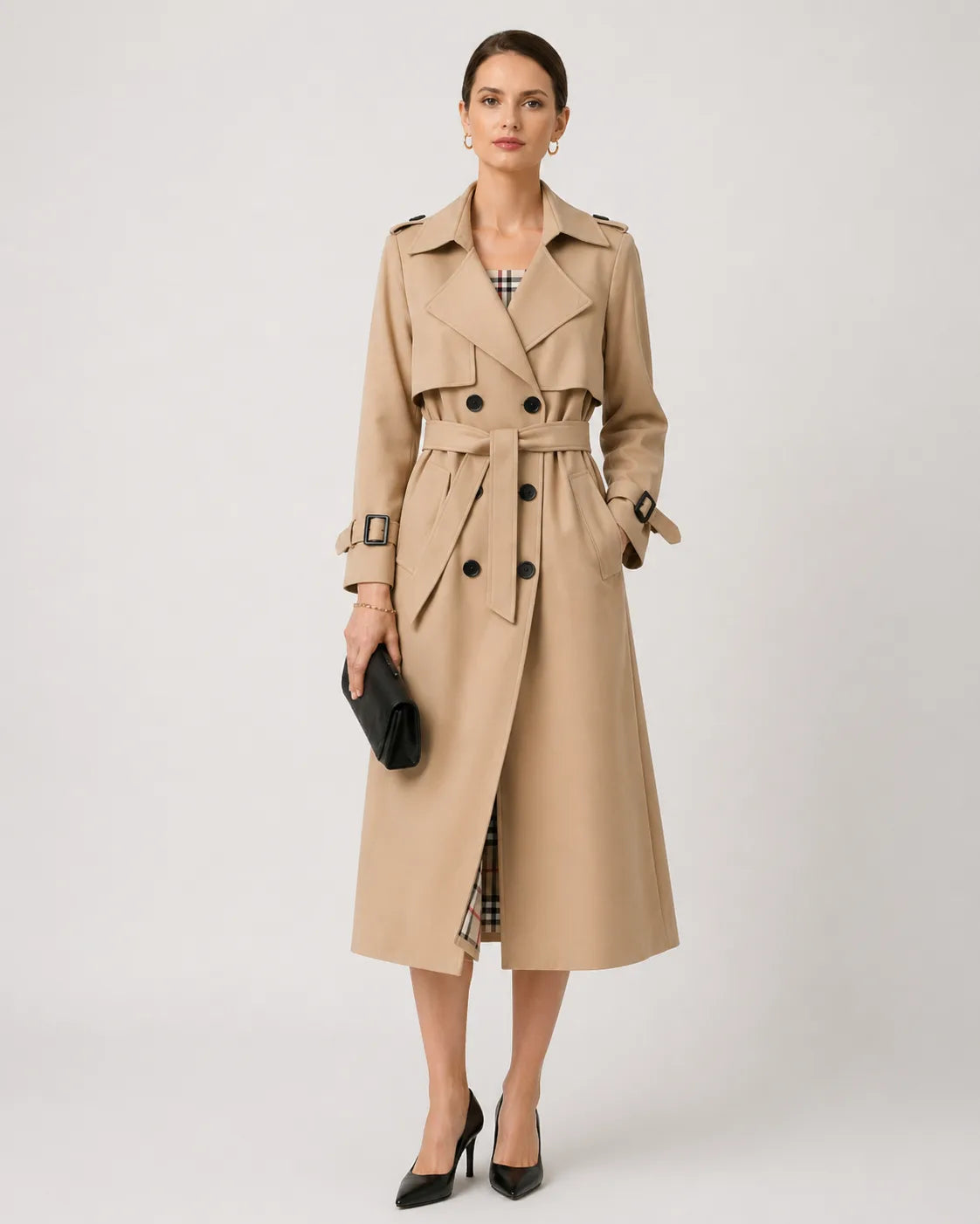 Woman wearing a beige belted trench coat over a checked dress with black heeled shoes, styled for the city