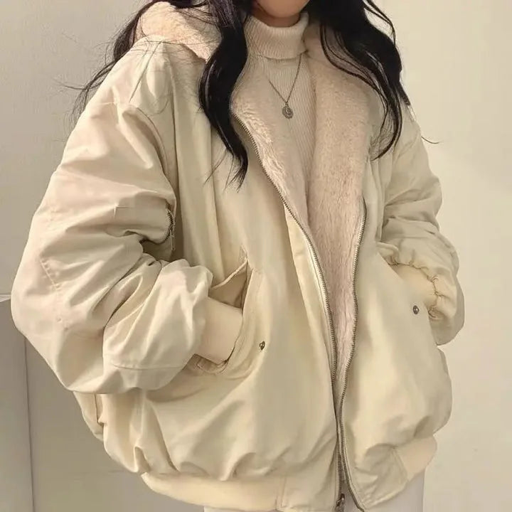Close-up front view of an oversized beige double-layer jacket with a fleece-lined hood, worn open over a cream polo neck jumper