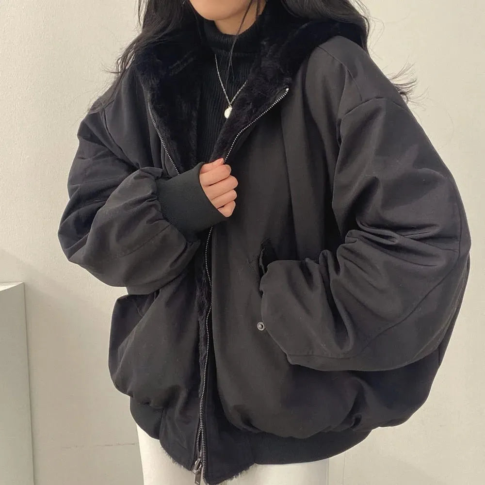 Front view of a black double-layer hooded jacket with faux-fur lining, worn zipped partway with hands tucked into the pockets