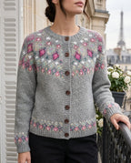 Close-up of a grey fair isle cardigan with pink, teal and cream diamond yoke pattern and dark wooden buttons down the front