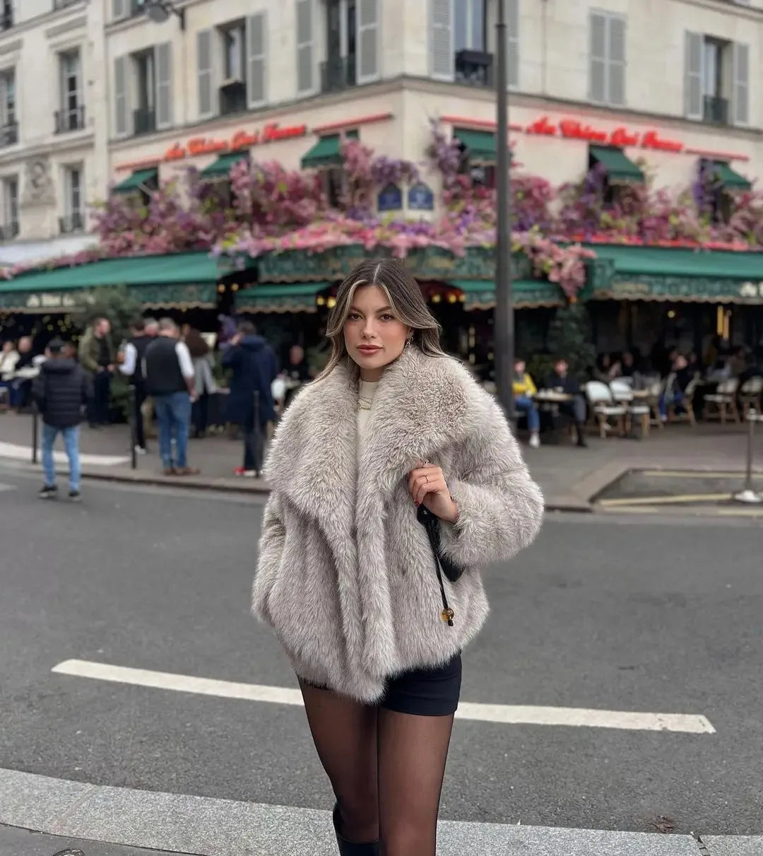 Woman adjusting her hair while wearing the cropped black faux fur coat over a sheer lace bodysuit
