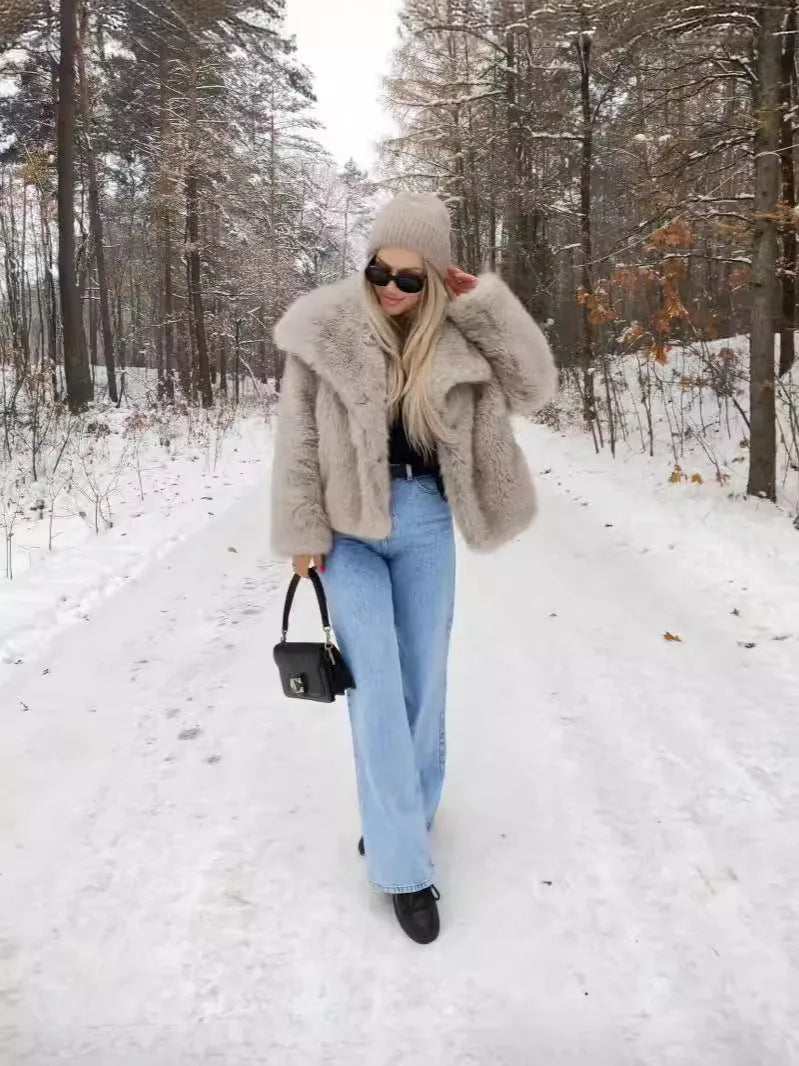 Three-quarter view of the model walking with the faux fur coat draped over her shoulders
