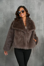 Full outfit shot showing the fur coat, black trousers and ankle boots on a city street