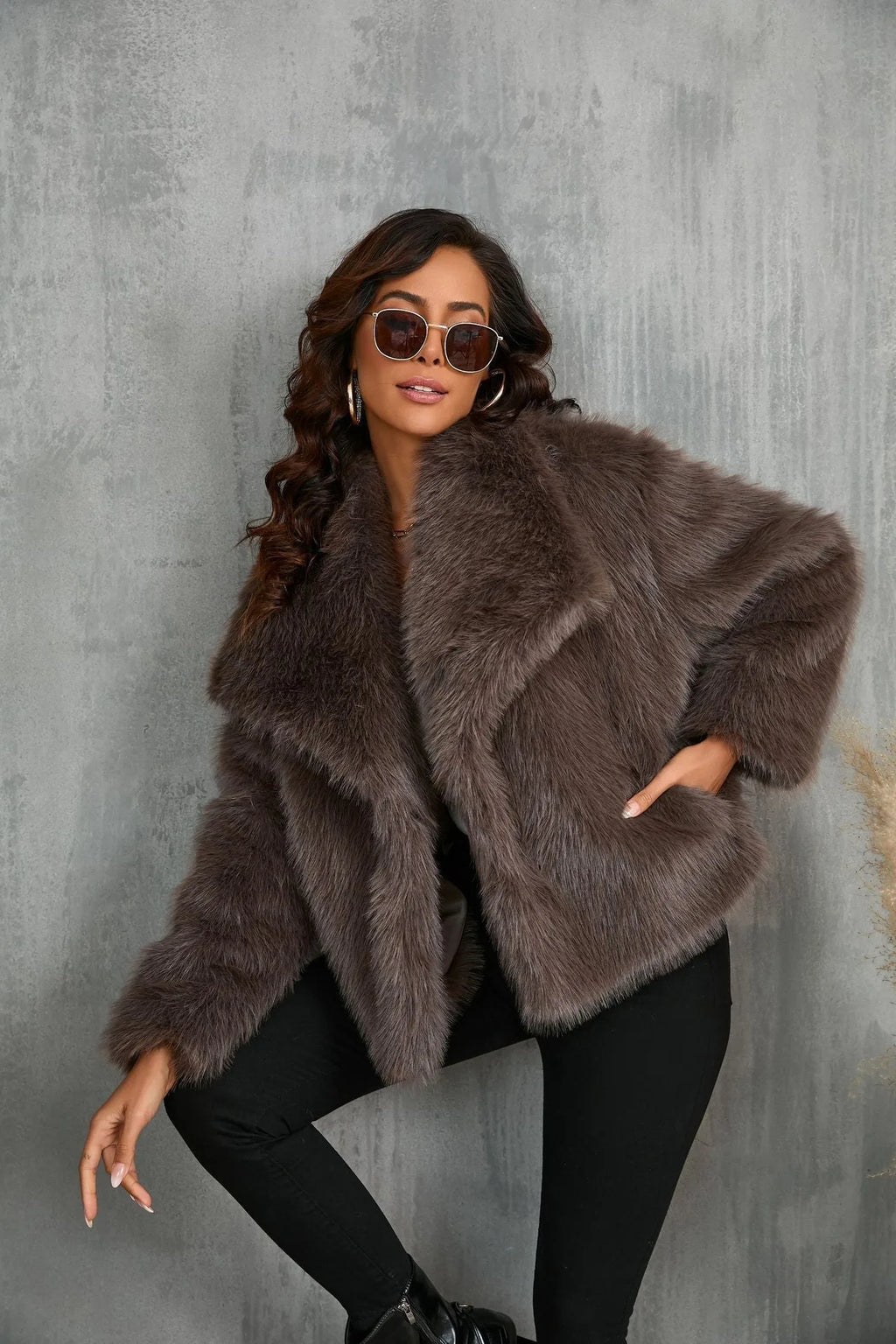Woman standing with one leg raised against a wall, showcasing the coat's wide collar and cropped length