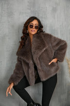 Woman standing with one leg raised against a wall, showcasing the coat's wide collar and cropped length