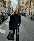 Close-up front view of the cropped black faux fur coat showing its plush texture and wide lapel collar