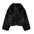 Woman wearing the black faux fur coat open over a black lace top with jeans and a shoulder bag