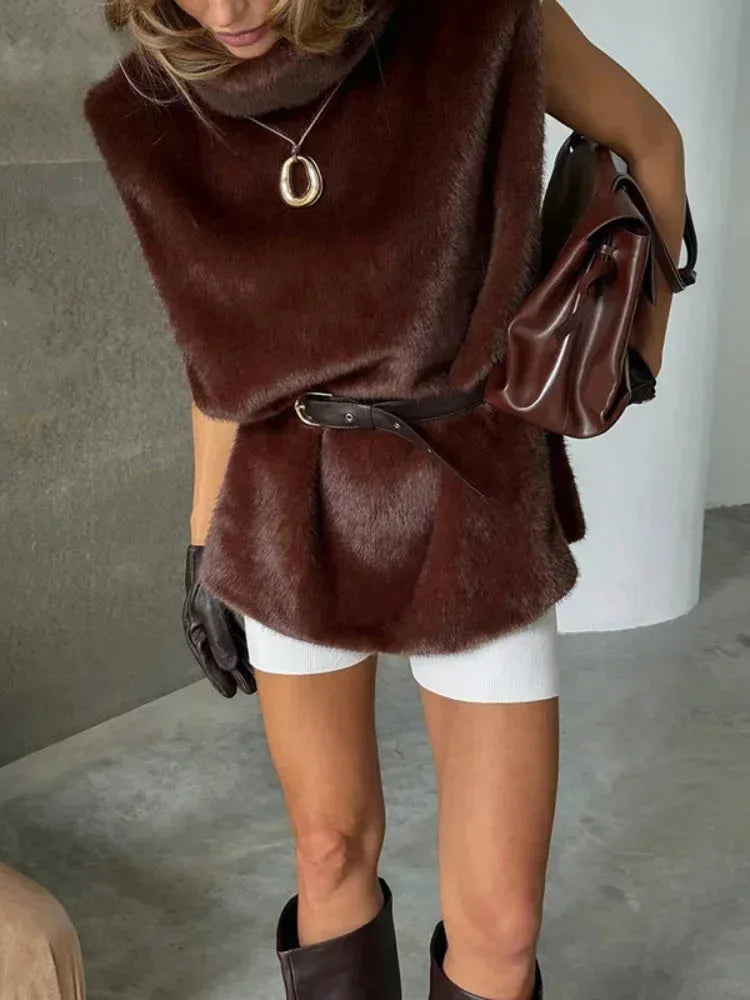 Close-up side view of a burgundy faux fur gilet belted at the waist over a tan top and white shorts