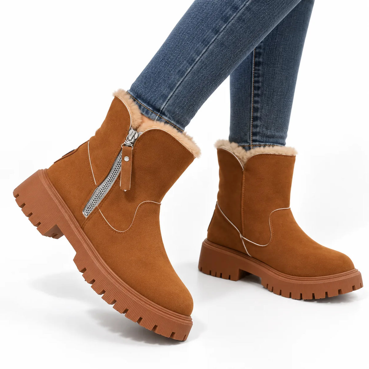 Side view of brown suede-look ankle boot with faux-fur trim, silver zip and chunky lug sole, worn with jeans