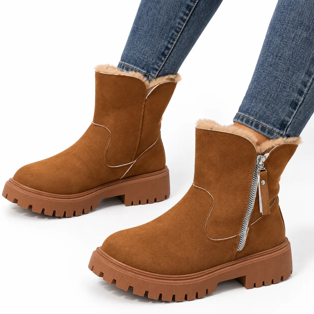 Front angle of both brown faux-fur lined ankle boots with visible stitched panel and ridged rubber sole