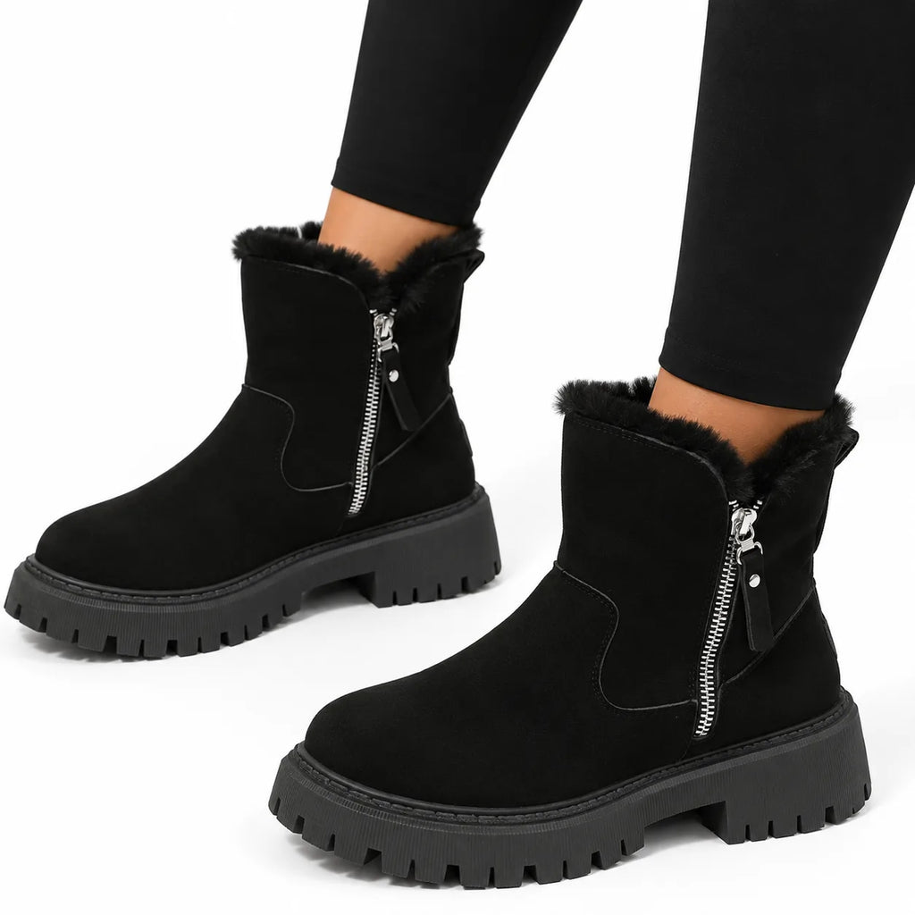 Pair of black suede-look ankle boots with fluffy faux-fur collar, side zip and thick lug outsole, worn with leggings