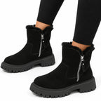 Pair of black suede-look ankle boots with fluffy faux-fur collar, side zip and thick lug outsole, worn with leggings