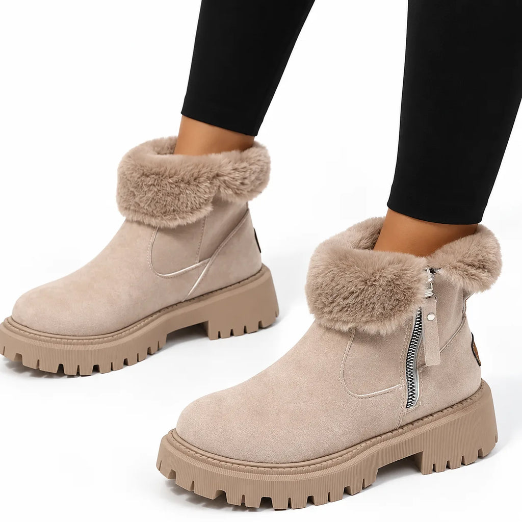 Close-up side view of beige ankle boot with folded-over faux-fur cuff, zip pull and ribbed platform sole