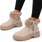 Close-up side view of beige ankle boot with folded-over faux-fur cuff, zip pull and ribbed platform sole
