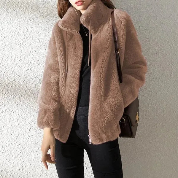Close-up of a light taupe faux fur jacket showing the soft textured pile and drawstring collar detail