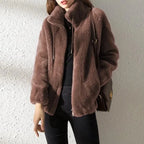 Chocolate brown faux fur jacket worn with black trousers, showing the full-length zip and wide sleeves