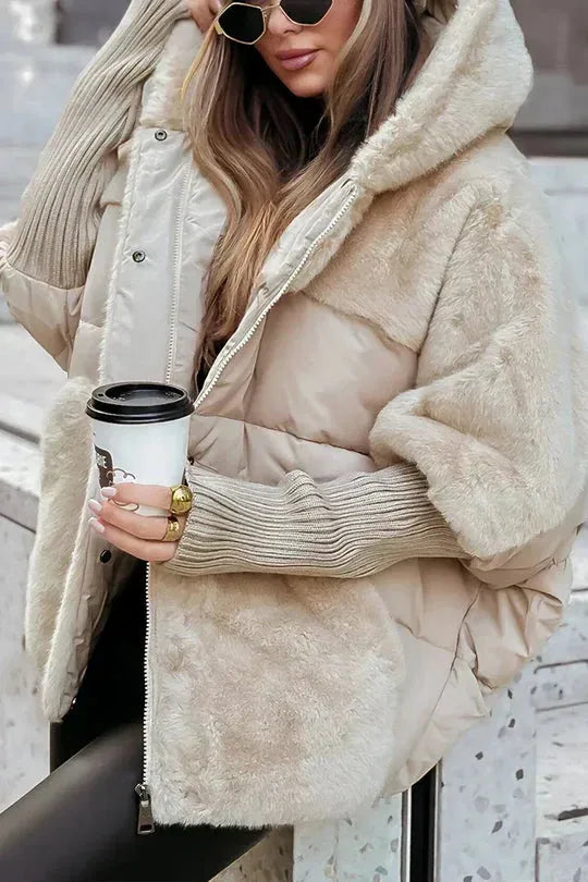 Beige puffer jacket with faux fur hood and sleeves, worn with sunglasses while holding a coffee cup