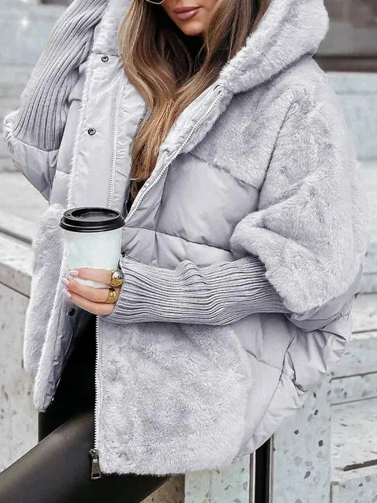 Grey puffer jacket with plush faux fur hood and sleeves, ribbed cuffs, side view holding a coffee cup