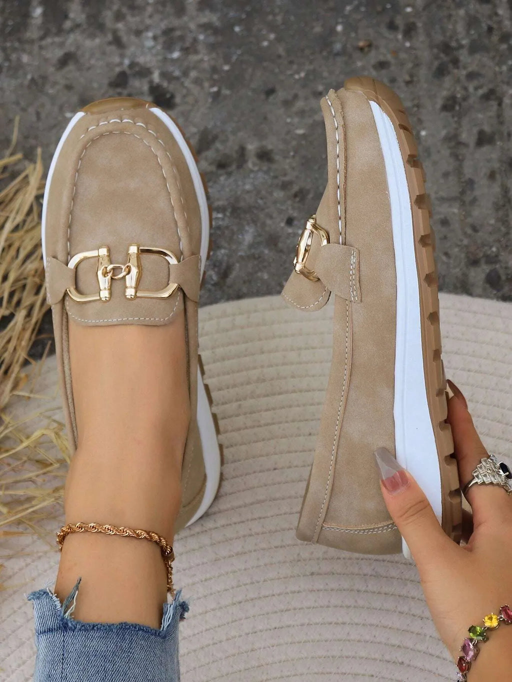 Front view of khaki loafer pair showing stitched moccasin toe and gold buckle trim